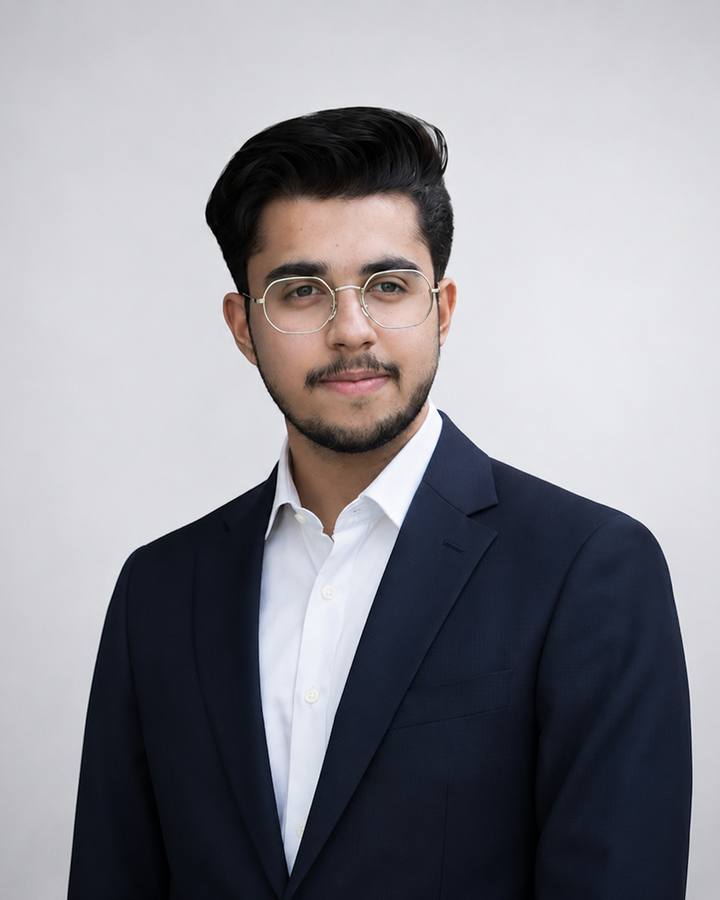 Aliyan Shah, founder of Fluigen, in a navy suit and white shirt, smiling at the camera